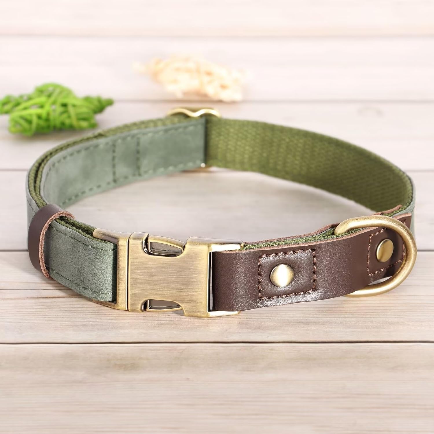Dog collar with green and brown leather on a wooden surface