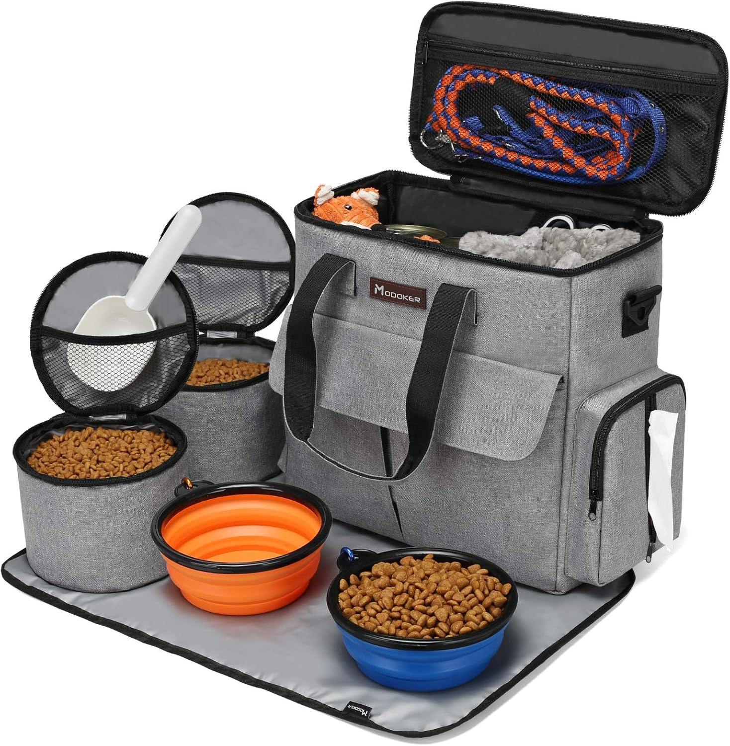 Gray pet travel bag with pet supplies including bowls, food, and leashes on a white background
