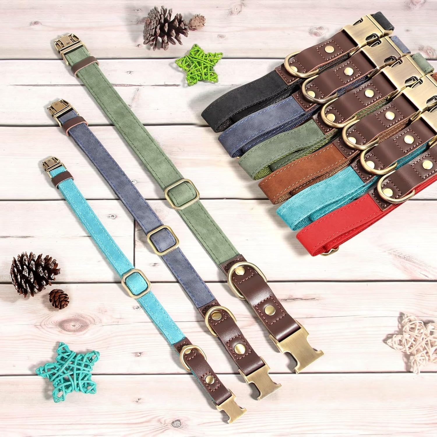 Set of colorful leather collars with brass buckles on a wooden surface.